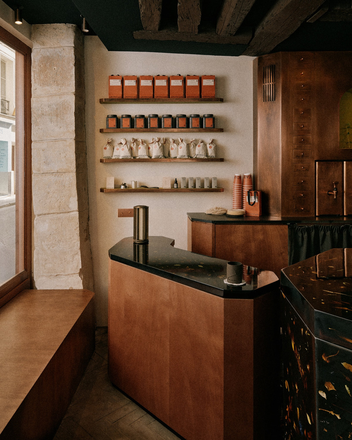 The copper counter, shelves of plants and seating at Apoticari’s La Tisanerie